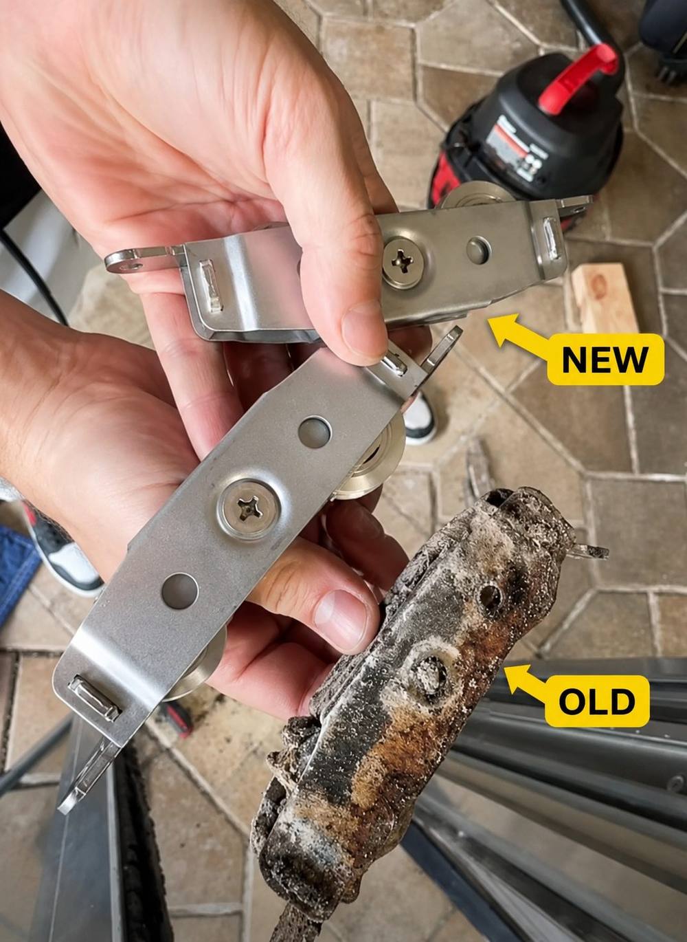 Old corroded sliding door roller next to a new replacement roller, held in hand